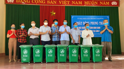 đại diện lãnh đạo địa phương tặng thùng rác cho làng.JPG